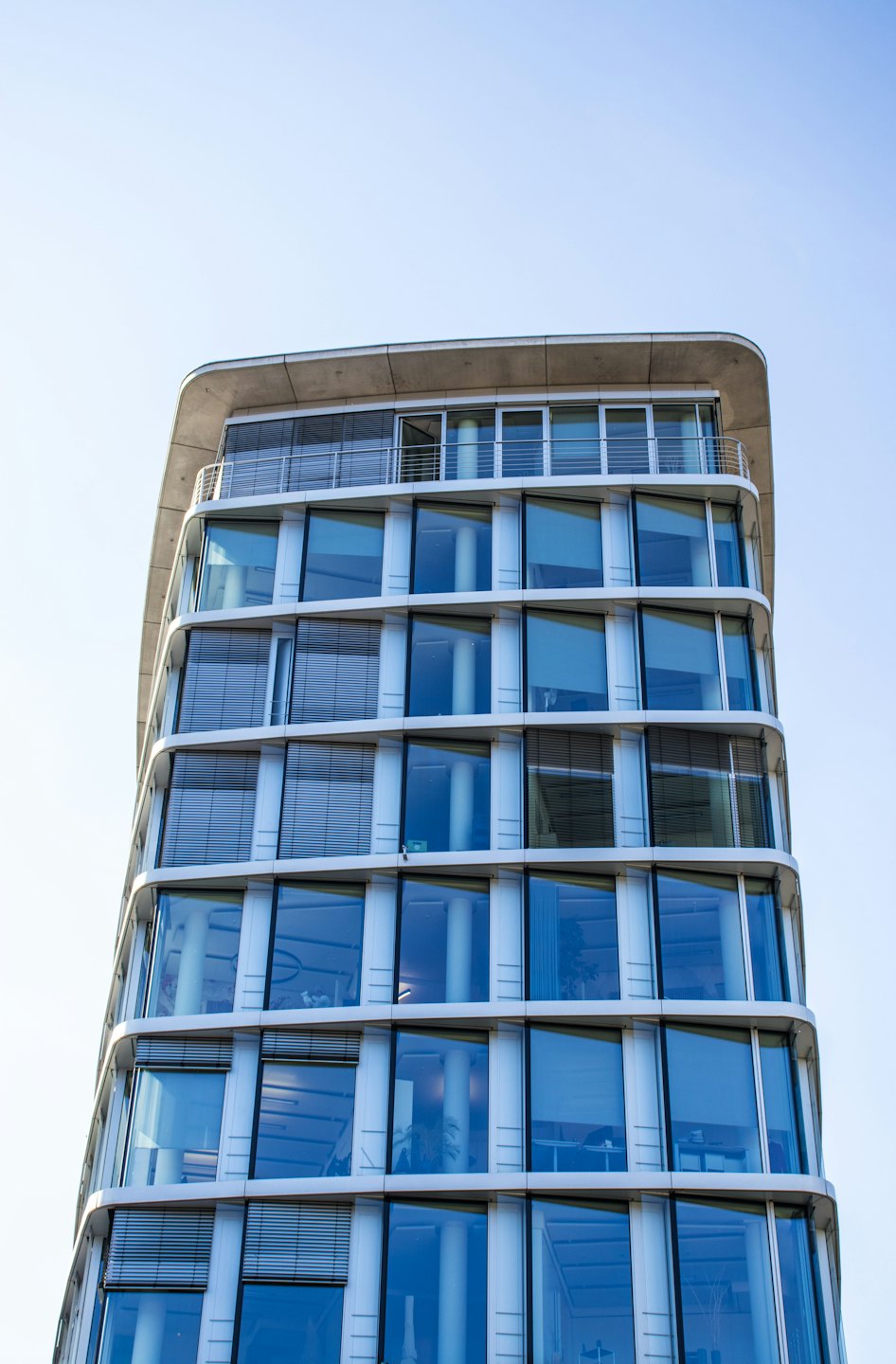 Modernes Bürogebäude mit geschwungener Glasfassade.
